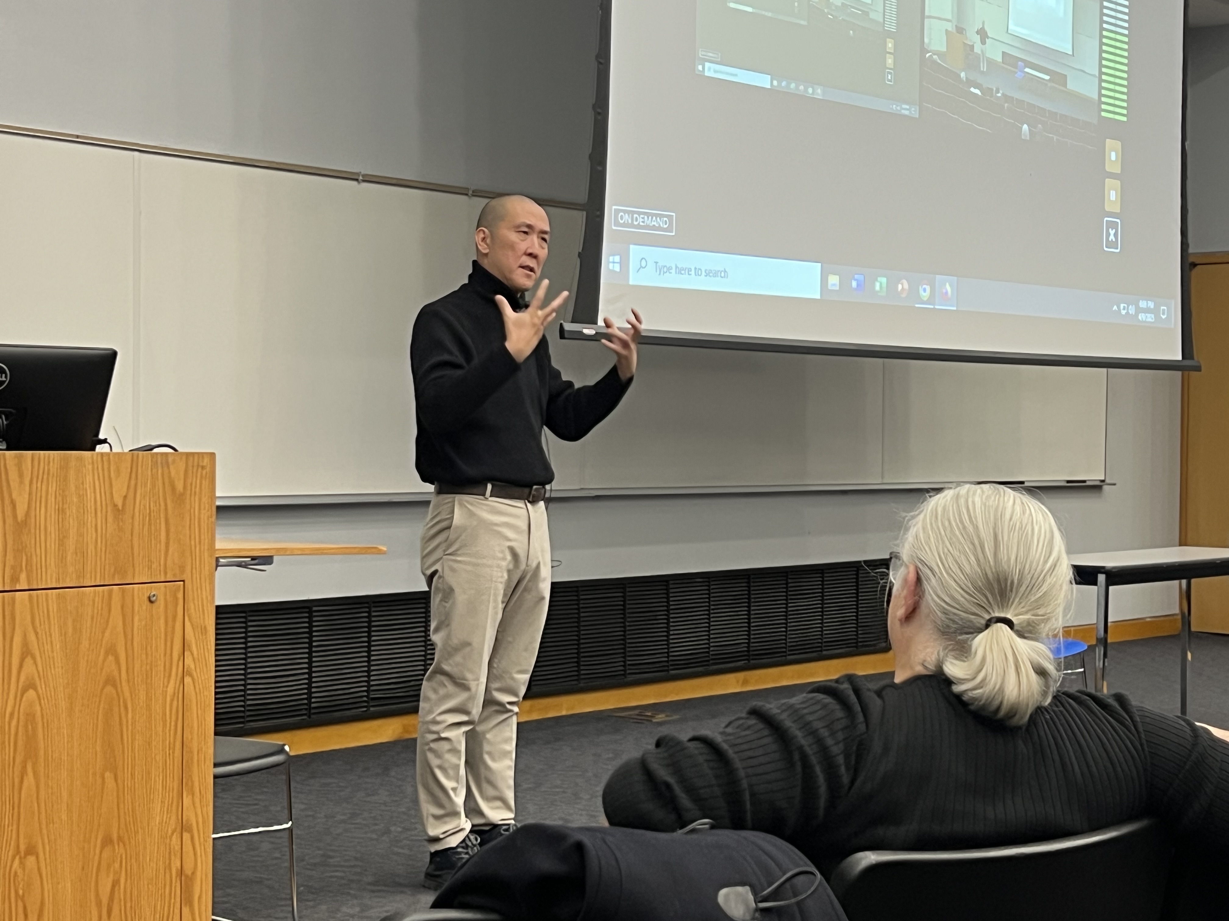 Jimmy Yu delivers the Ziffren Lecture standing on stage with expressive hands