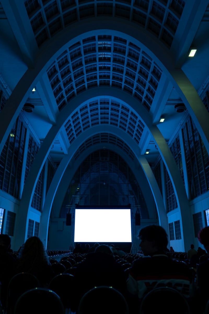 Movie Theater inside modern cathedral with neon glow 