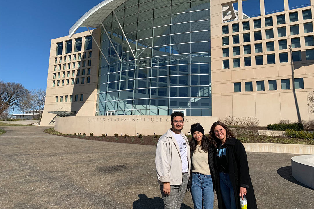 Three students standing outside the US Institute for Peace
