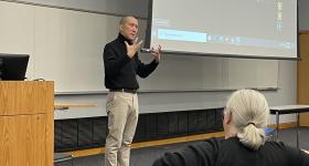 Jimmy Yu delivers the Ziffren Lecture standing on stage with expressive hands